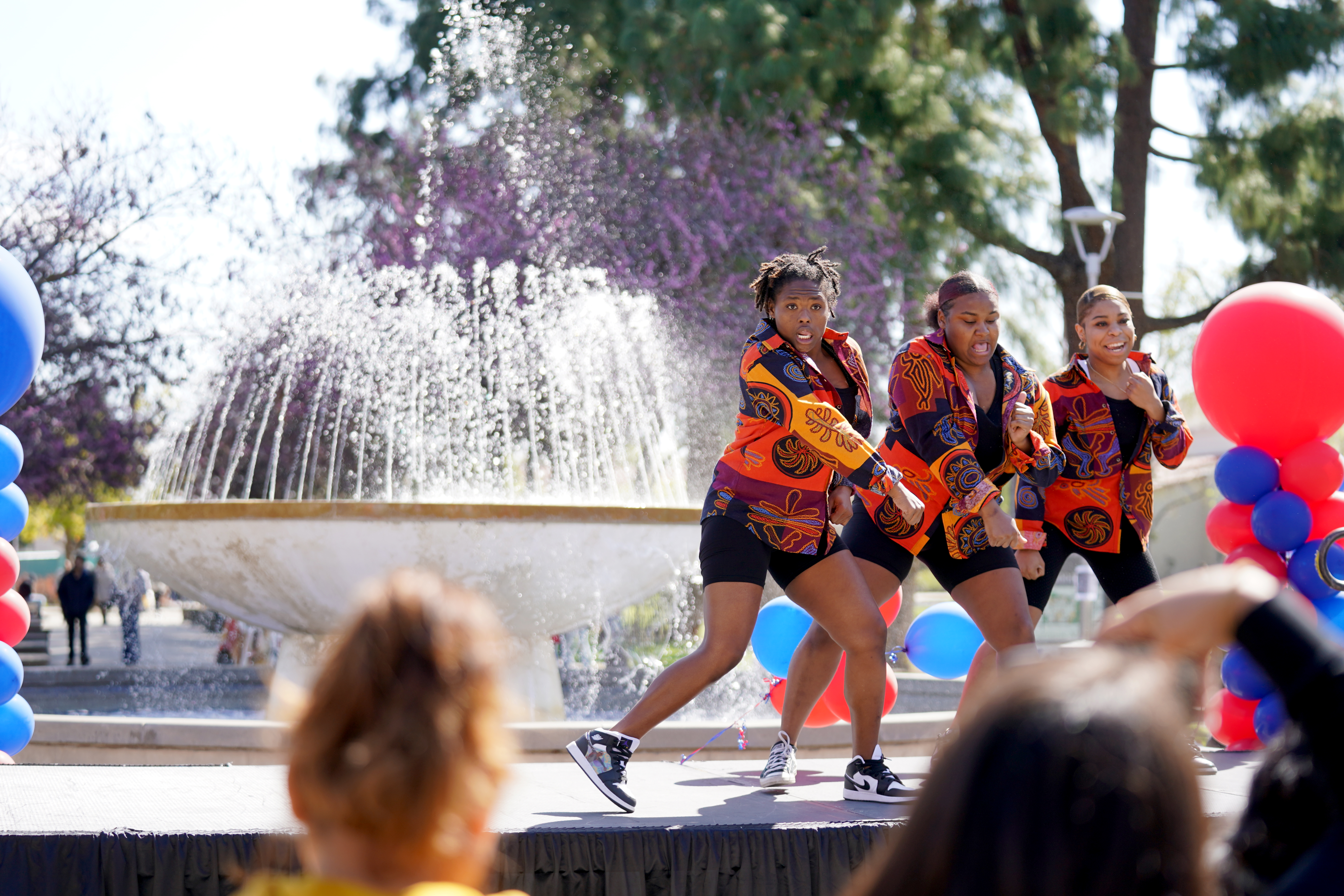 students dancing on fountain